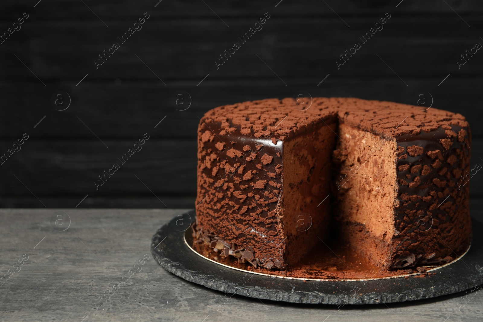 Photo of Delicious chocolate truffle cake on grey textured table, space for text