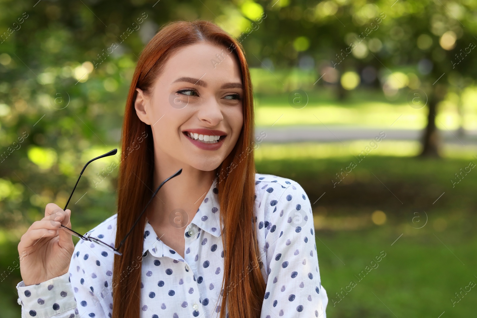 Photo of Portrait of happy young woman outdoors. Space for text. Attractive lady smiling and posing for camera