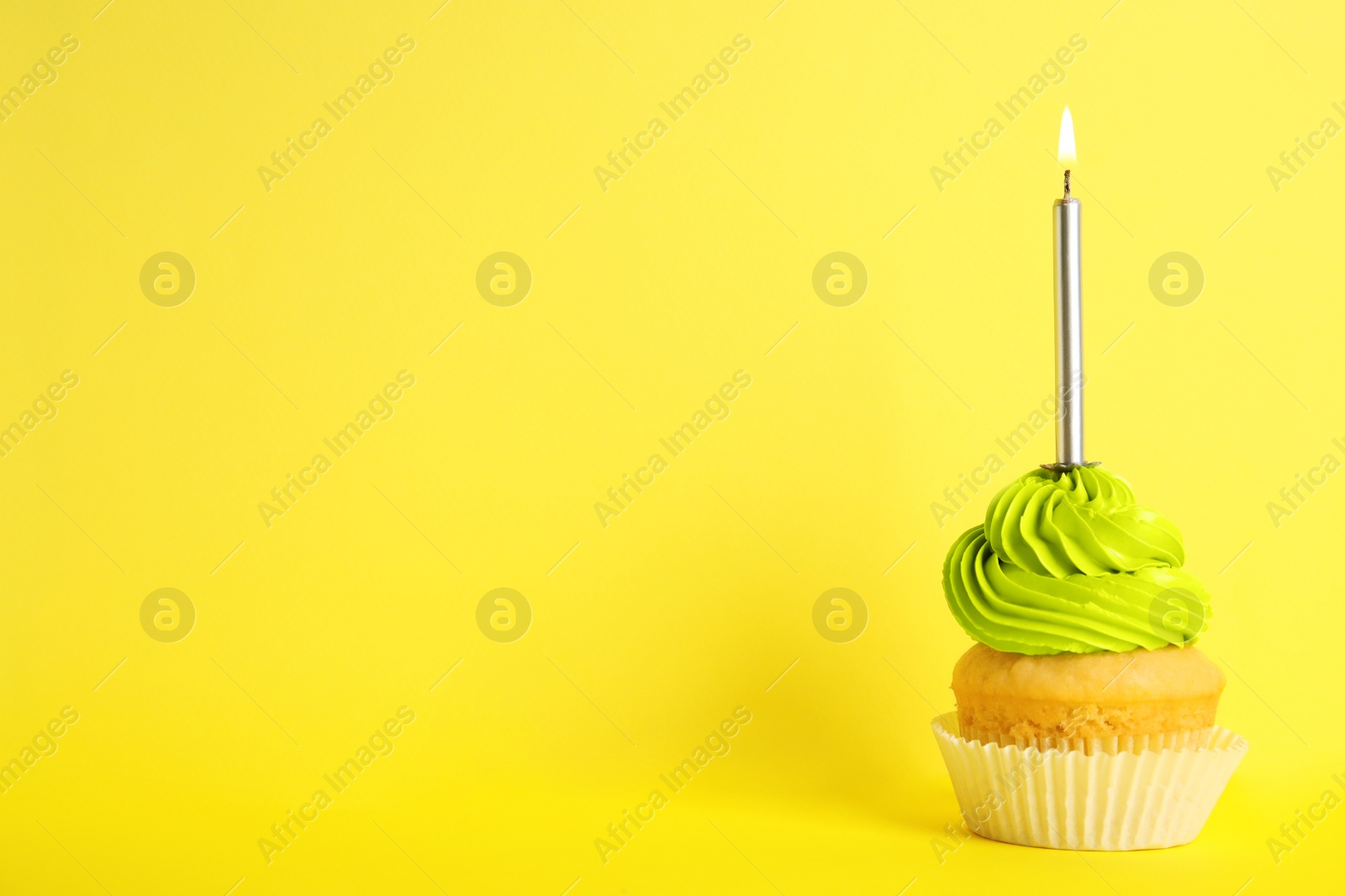 Photo of Birthday cupcake with candle on yellow background, space for text