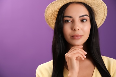 Portrait of beautiful young woman on purple background