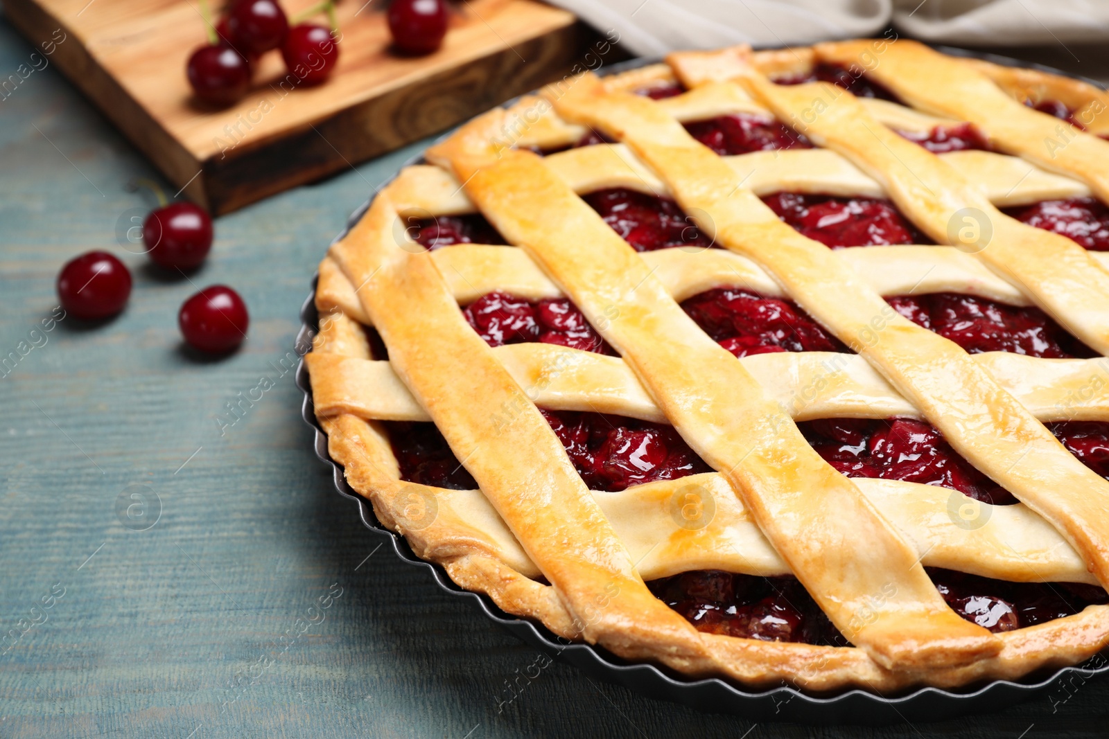 Photo of Delicious fresh cherry pie on light blue wooden table, closeup