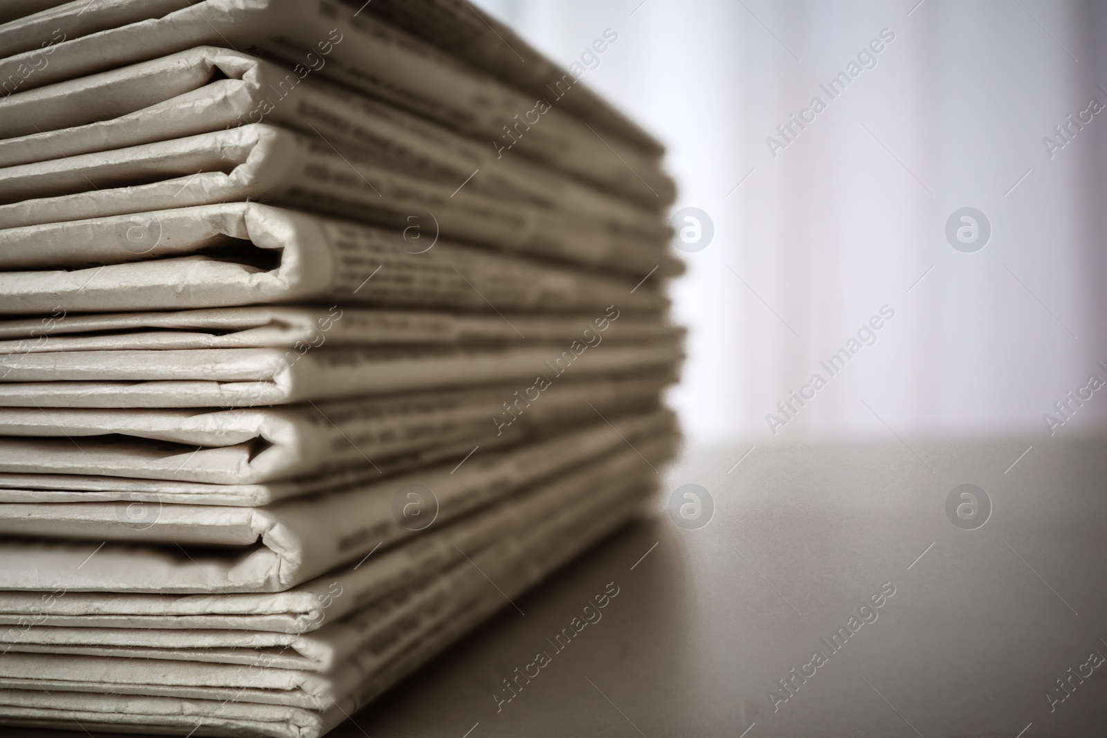 Image of Stack of newspapers on grey table, space for design. Journalist's work