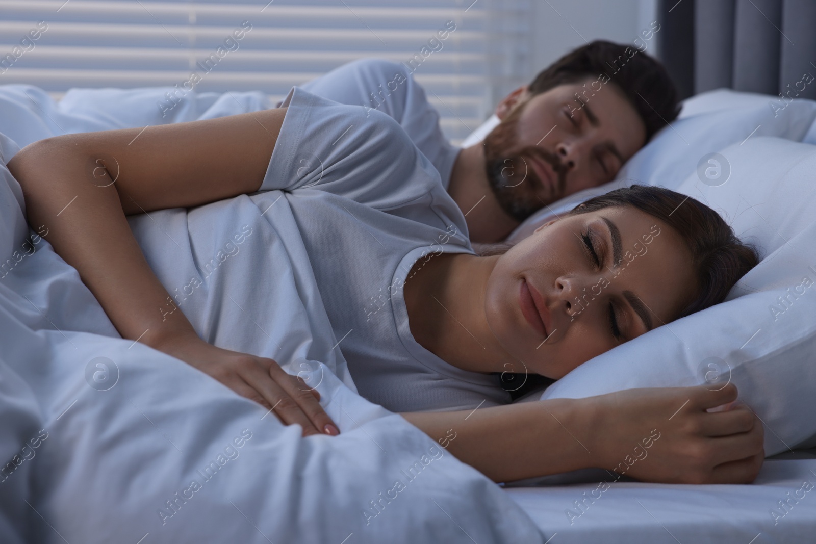 Photo of Lovely couple sleeping together in bed at night