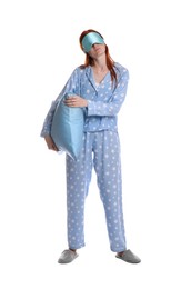 Photo of Young woman wearing pajamas and slippers with pillow in sleepwalking state on white background