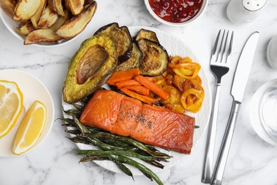 Photo of Tasty cooked salmon and vegetables served on white marble table, flat lay. Healthy meals from air fryer
