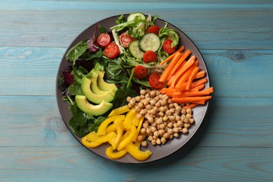 Photo of Balanced diet and vegetarian foods. Plate with different delicious products on light blue wooden table, top view