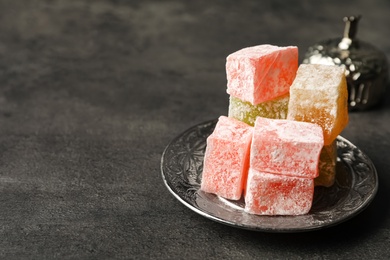Photo of Turkish delight dessert on dark table. Space for text