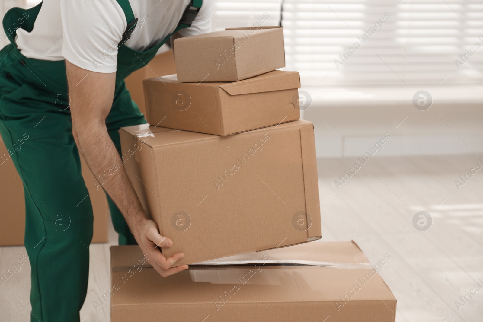 Photo of Man with cardboard boxes in room, closeup. Moving service