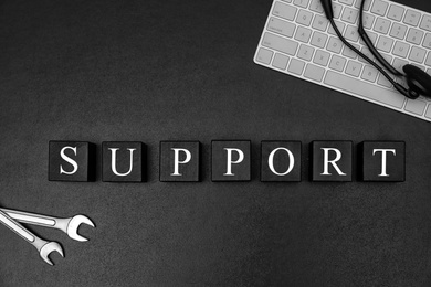 Photo of Cubes with word "SUPPORT" on dark background, flat lay composition. Technical service