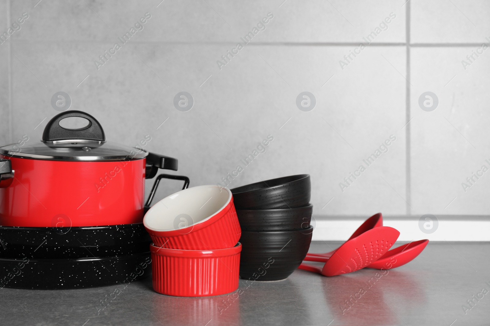 Photo of Set of different cooking utensils on grey countertop in kitchen