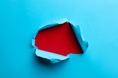 Hole in light blue paper on red background