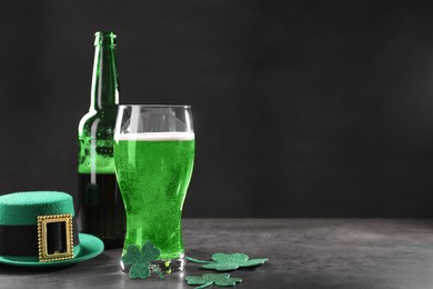 St. Patrick's day celebration. Green beer, leprechaun hat and decorative clover leaves on grey table. Space for text