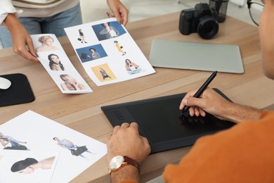 Photo of Professional retoucher with colleague working at desk in office, closeup