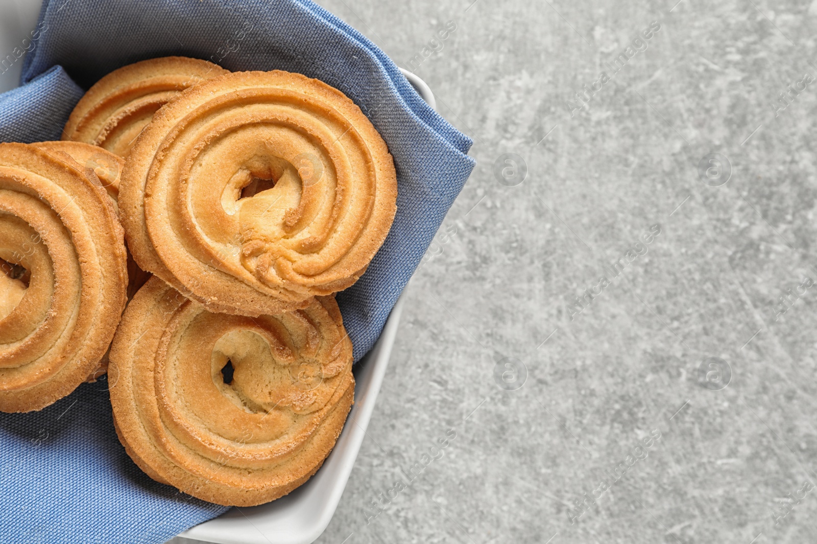 Photo of Bowl with Danish butter cookies on grey table, top view. Space for text