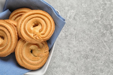 Photo of Bowl with Danish butter cookies on grey table, top view. Space for text