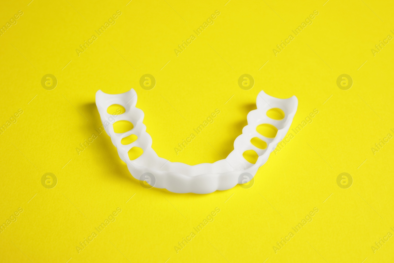 Photo of Dental mouth guard on yellow background. Bite correction