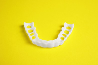 Photo of Dental mouth guard on yellow background. Bite correction