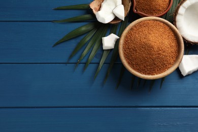 Flat lay composition with natural coconut sugar on blue wooden table, space for text