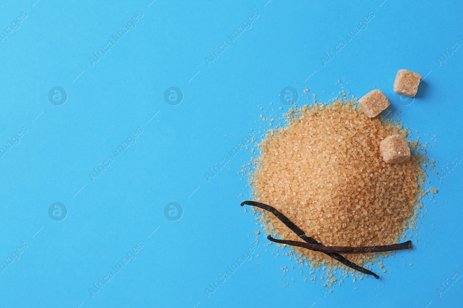 Photo of Pile of brown vanilla sugar on color background, top view