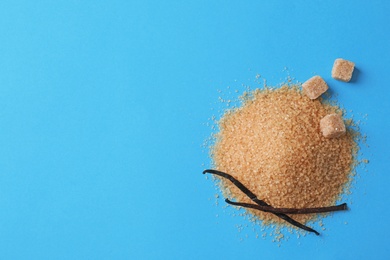 Photo of Pile of brown vanilla sugar on color background, top view