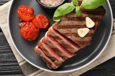 Photo of Delicious grilled beef steak with tomatoes and spices table, top view