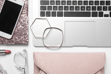 Photo of Flat lay composition with laptop, mobile phone and fashion blogger's stuff on white background