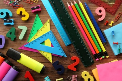 Flat lay composition with many colorful numbers and stationery on wooden table
