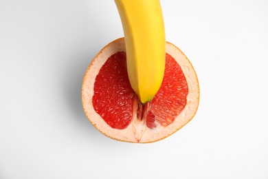 Photo of Fresh grapefruit and banana on white background, top view. Sex concept