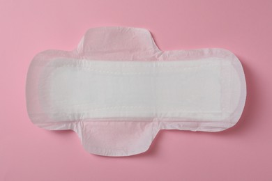 Photo of Sanitary napkin on pink background, top view. Gynecology concept