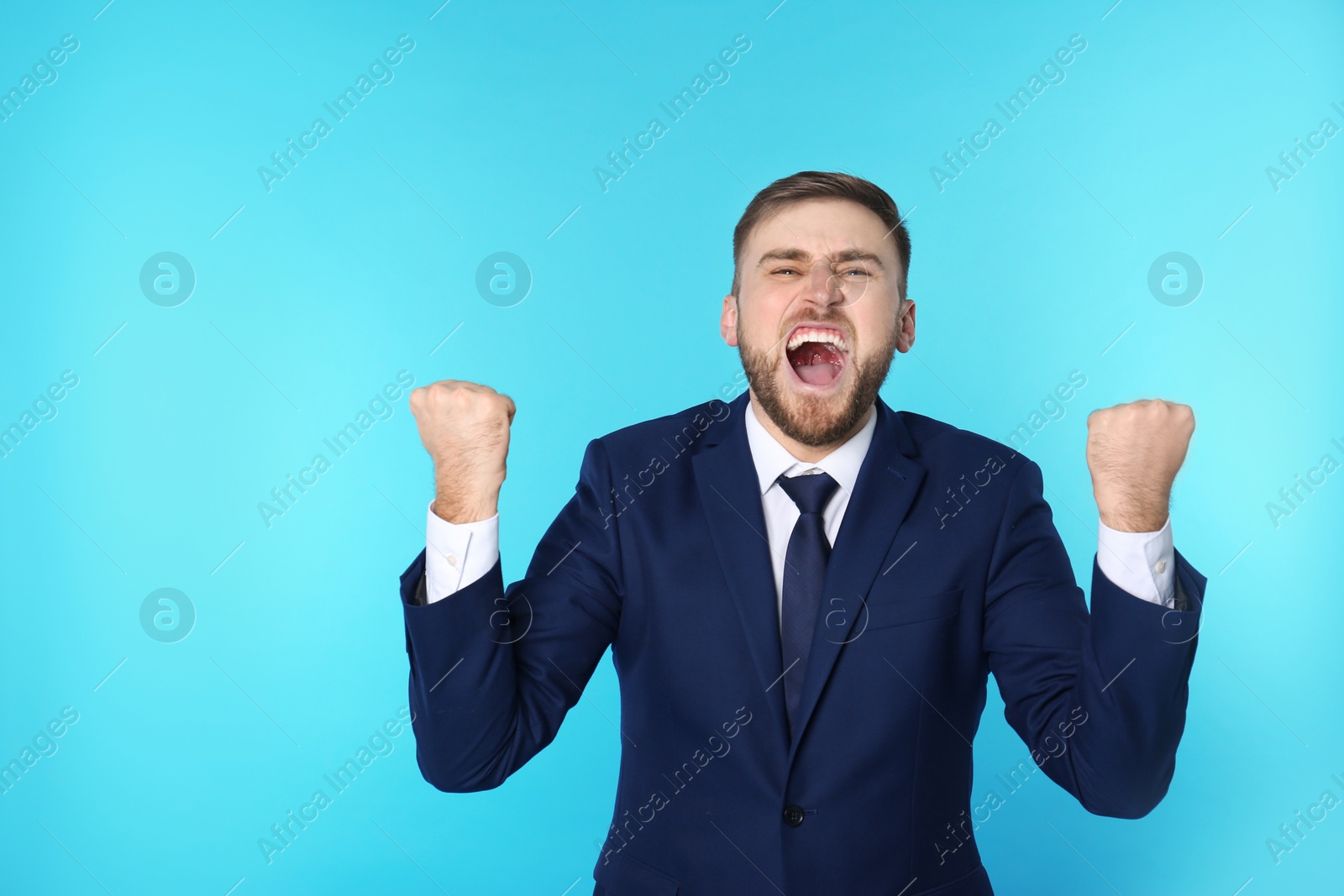 Photo of Portrait of emotional young businessman on color background