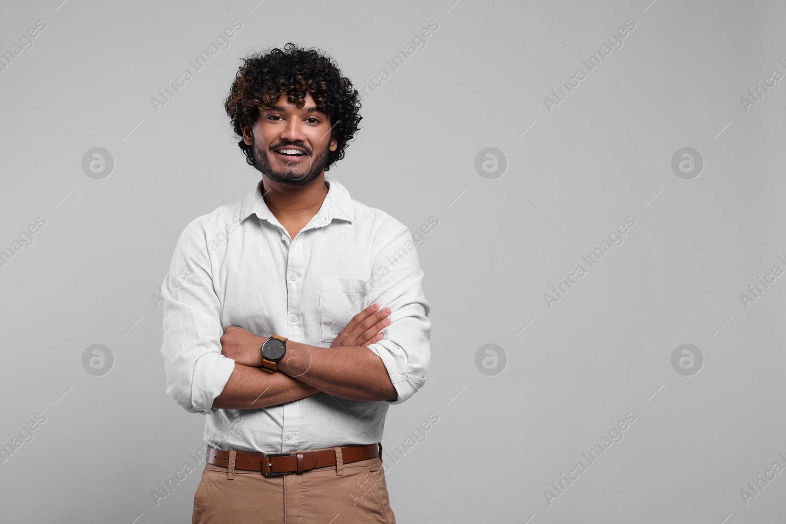Photo of Handsome smiling man on light grey background, space for text