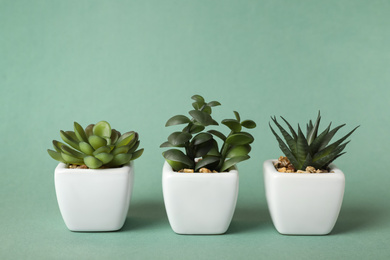 Photo of Beautiful artificial plants in flower pots on color background