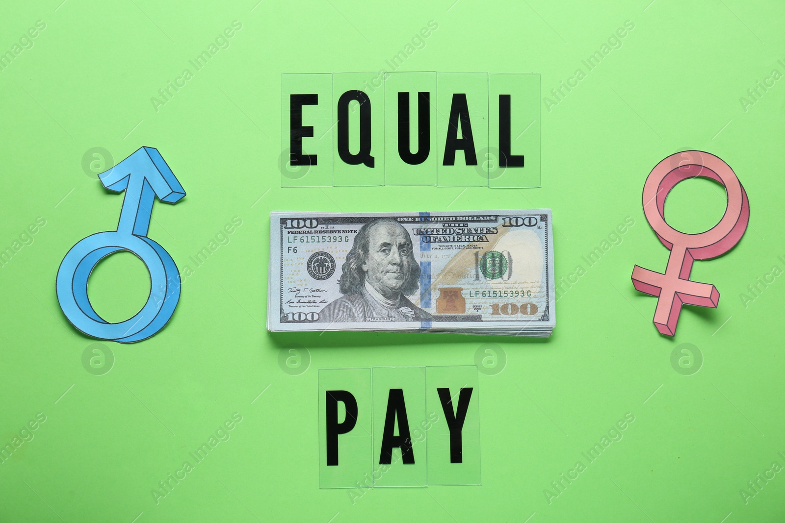 Photo of Equal pay. Gender symbols with stack of dollar banknotes on green background, flat lay