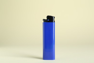 Photo of Stylish small pocket lighter on beige background