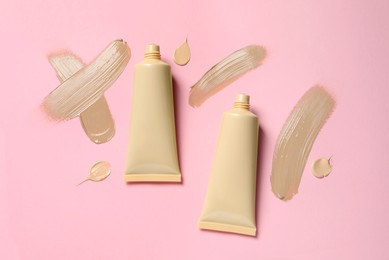 Liquid foundations and swatches on pink background, flat lay