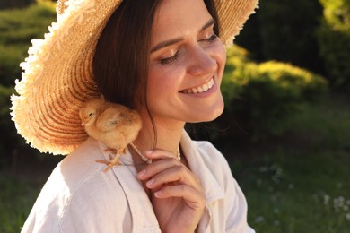 Photo of Beautiful woman with cute chick outdoors. Baby animal