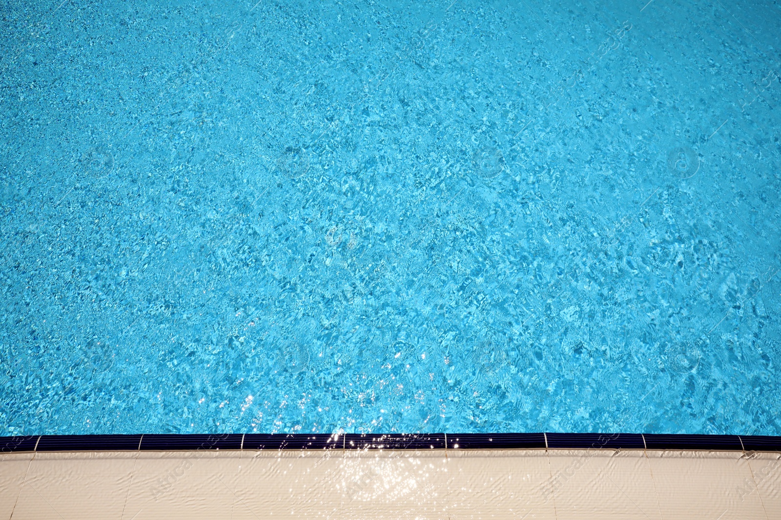 Photo of Outdoor swimming pool with clear water on sunny day, above view