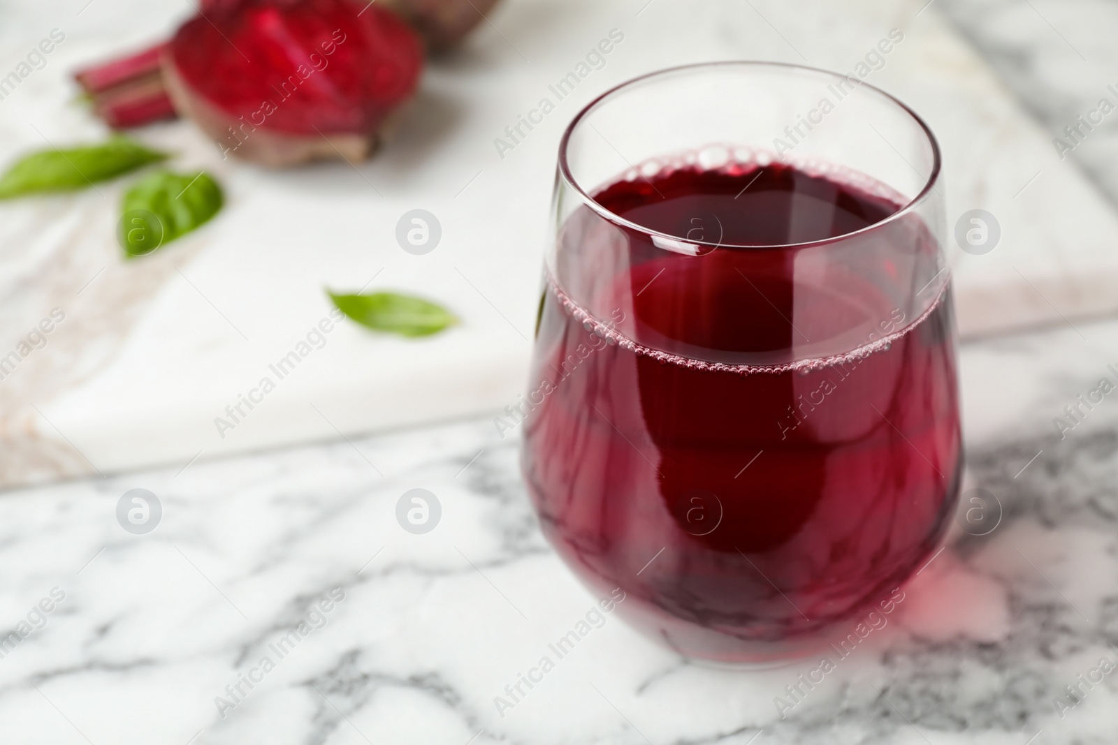 Photo of Glass with fresh beet juice on table