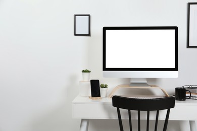 Photo of Cozy workspace with computer, smartphone and stationery on wooden desk at home