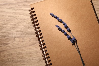 Photo of Beautiful preserved lavender flowers and notebook on wooden table, top view. Space for text