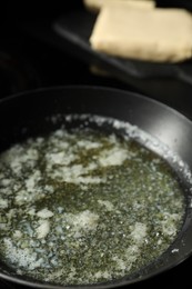 Photo of Melting butter in frying pan on table, closeup