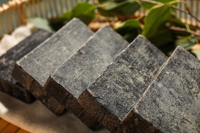 Photo of Natural tar soap in wicker basket, closeup