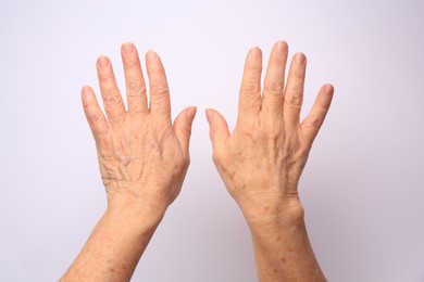 Photo of Closeup view of older woman's hands on white background