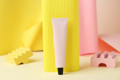 Photo of Composition with tube of hand cream on beige table