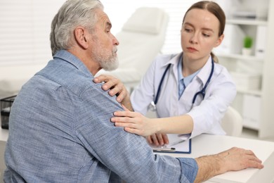 Photo of Arthritis symptoms. Doctor examining patient with shoulder pain in hospital