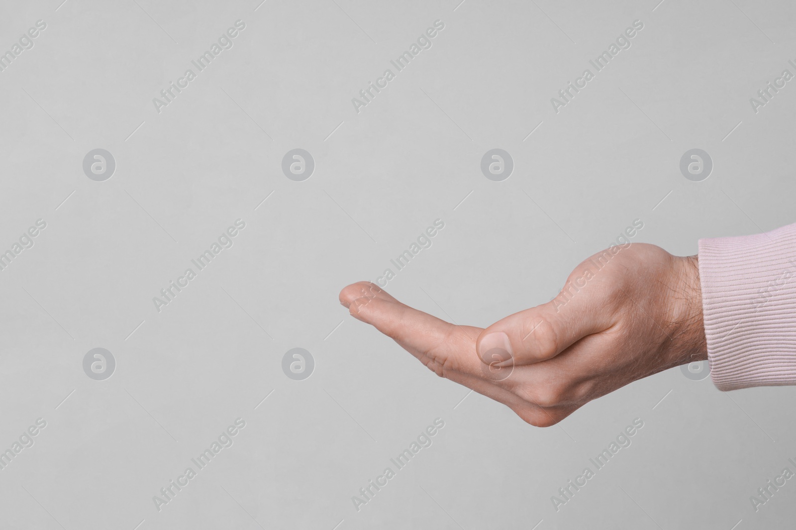 Photo of Female health. Man holding her hand on grey background, closeup with space for text