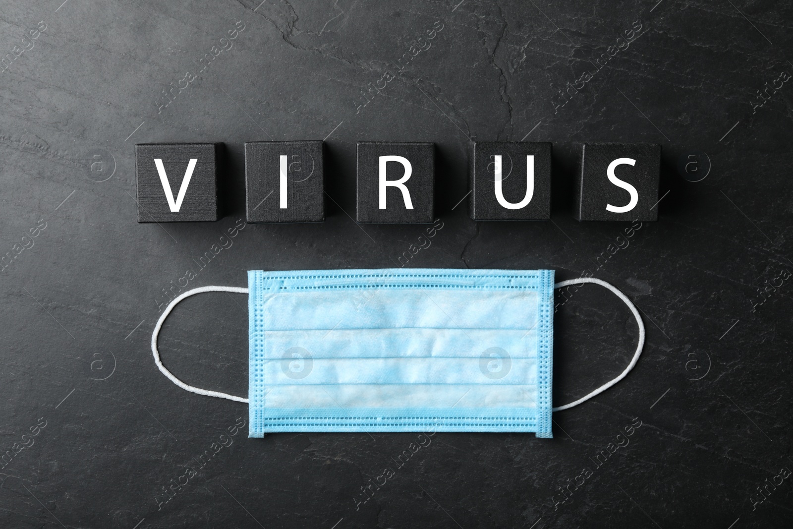 Photo of Cubes with word VIRUS and medical mask on black background, flat lay