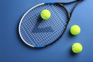 Photo of Tennis racket and balls on blue background, flat lay. Sports equipment