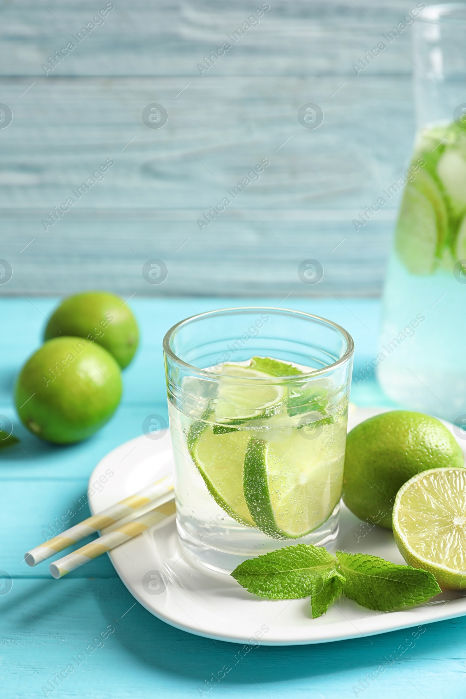 Photo of Natural lemonade with lime in glass on wooden table