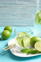 Natural lemonade with lime in glass on wooden table